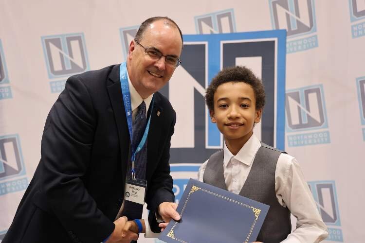 Jim Hop, entrepreneurship department chair, presents a certificate to a camper.