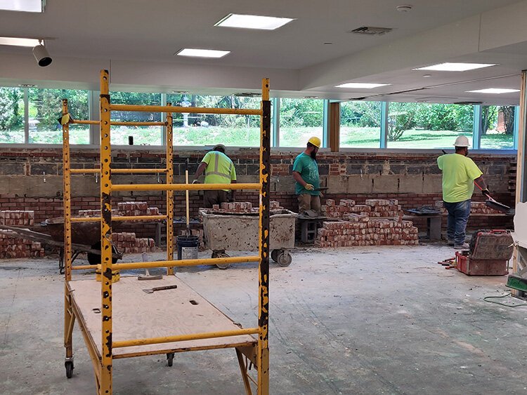 A construction crew is currently redoing the brick work in the story area.