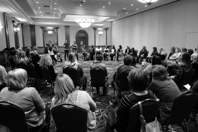 Women sat in a circle during one of the breakout sessions on yoga, breathing and reclaiming your peace with Amy Phoenix of the YWCA and Keri Kenny of Alignment 8 Yoga + Cycle.