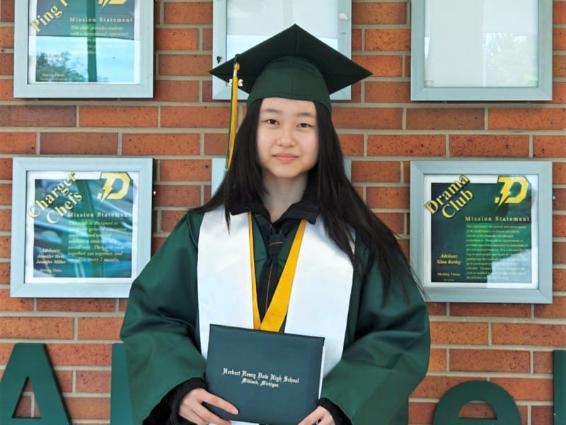 Graduate holding her diploma