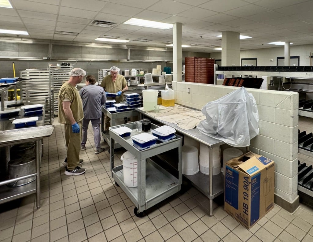 Inmates working with staff in kitchen