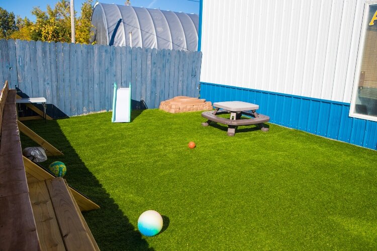Artificial grass and play equipment dots the outdoor therapy space.