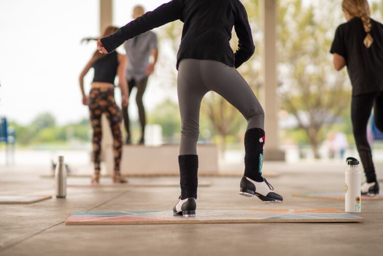 Tap dancers filled the park with sound and movement, attracting spectators to the pavilion.