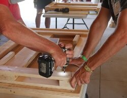 A core group of experienced volunteers and staff from Lowe’s Home Improvement help guide people through building their first bed.