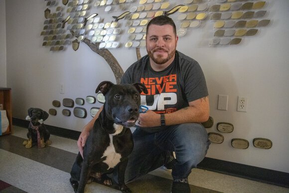 Anthony Trevino, a kennel attendant, plays with one of the dogs at the center.