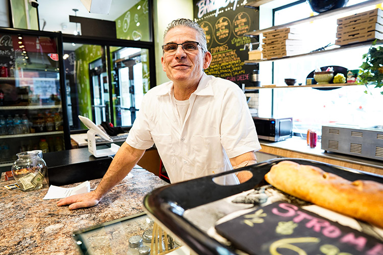 Owner of Brooklyn Boyz pizza, Kevin Novellino stands in his booth at City Market, an indoor market housing more than 20 local businesses.