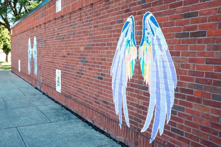 On a wall near the playground, angel wings encourage portraits and selfies.