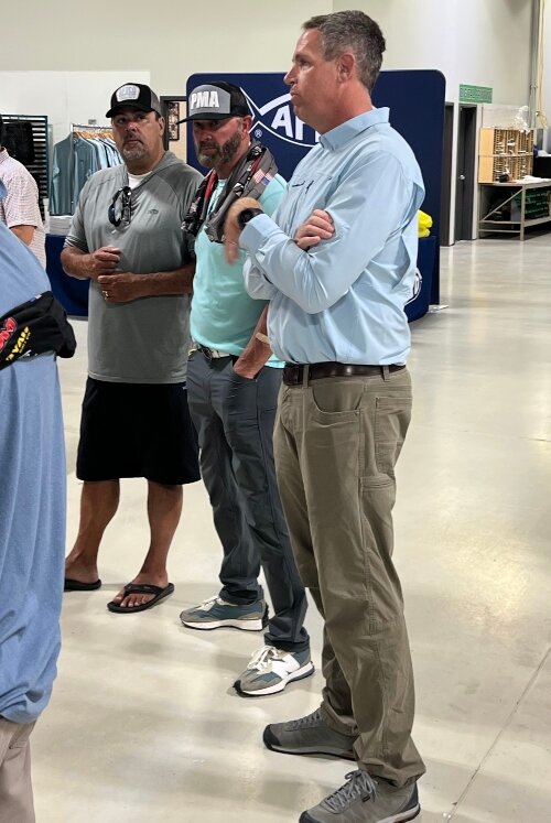 Mark Zona, Gerald Swindle, and Mike Valster talk with vendors, anglers, and reporters during the Major League Fishing Writers Conference held in Bay County in August.