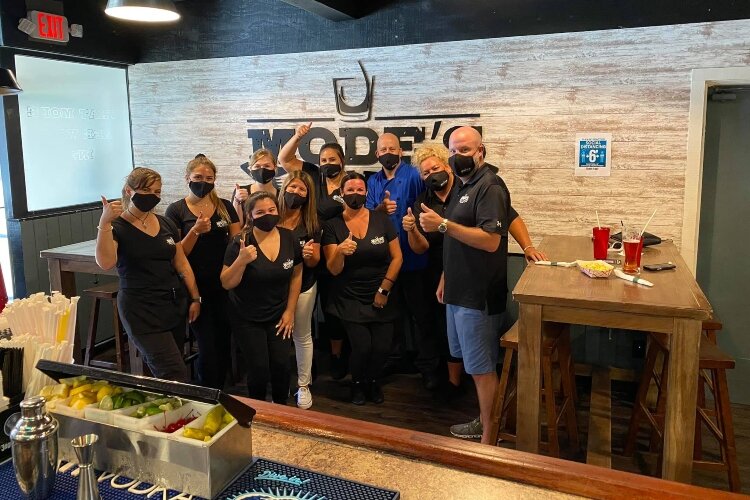 Matt Nemode poses with his staff. Since the devastating fire, businesses in town have organized fundraisers to help staff at Mode's Tavern and JR's All-Star Haircuts.