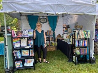 Leopard Print Books, Gifts & Curiosities is an independent bookstore based in Bay City. Owner Andrea Richmond poses at a summer pop-up shop. (Photo courtesy of Leopard Print Books, Gifts & Curiosities)