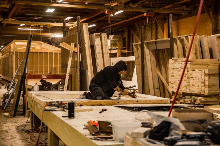 Craftsmen work inside the Fraser Road production facility, creating custom homes.