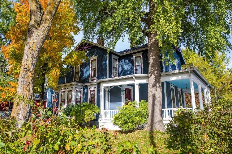 The single-story porch wraps around the southeast corner of the Mann House.
