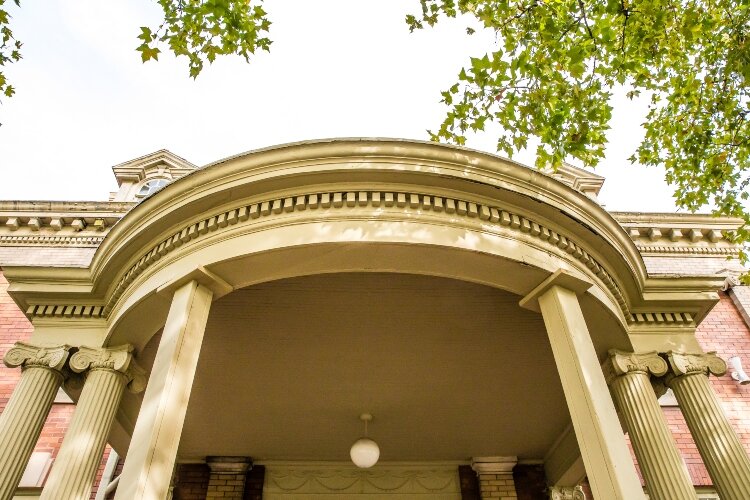 The central entrance, which faces Center Avenue, features a portico and terrace made of red quarry.