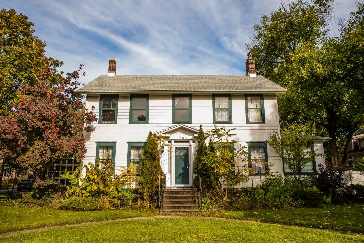 This two-story colonial-revival home was built in 1913. It features a symmetrical design formed by side-gable roofs, single story wings, and brick interior chimneys.