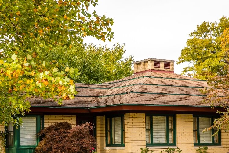 The home’s horizontal lines – including distinctive banding on a hipped roof – emphasis the house’s low profile.