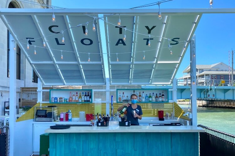 Port Huron’s social district includes a barge bar called CityFloats, which meanders the Black River at the Military Street Bridge. (Photo courtesy of Blue Water Area CVB)