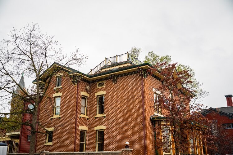 The home features formal facades, two polygonal bay windows, as well as a Widow's Walk on the roof.
