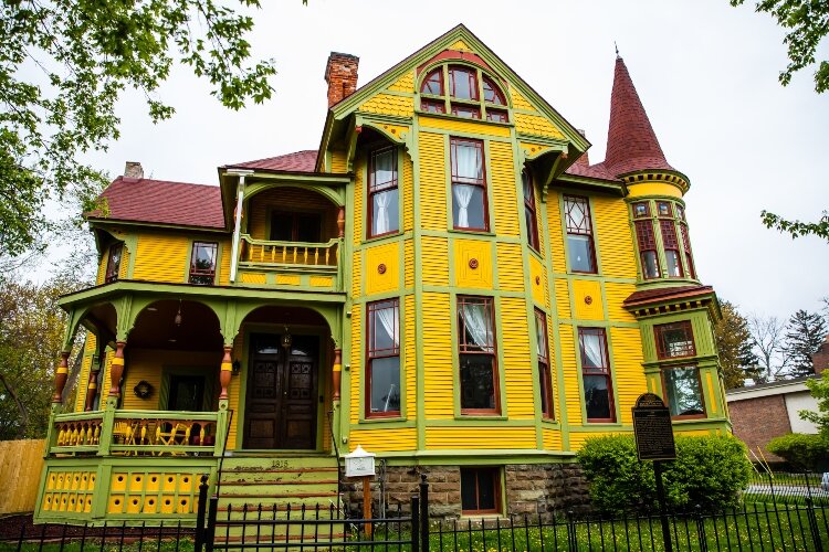 The 2 ½-story Queen Anne was constructed using a red-sandstone foundation in 1887. It features four cross-gables emanating from the house and a witch’s cap on the turret above the bay window facing Center and Lincoln.