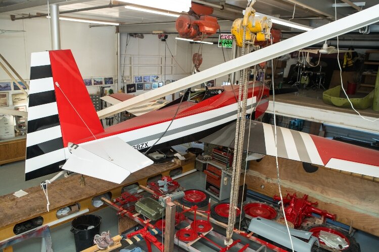 Current experiments inside the workshop include an airplane powered by a motorcycle engine.