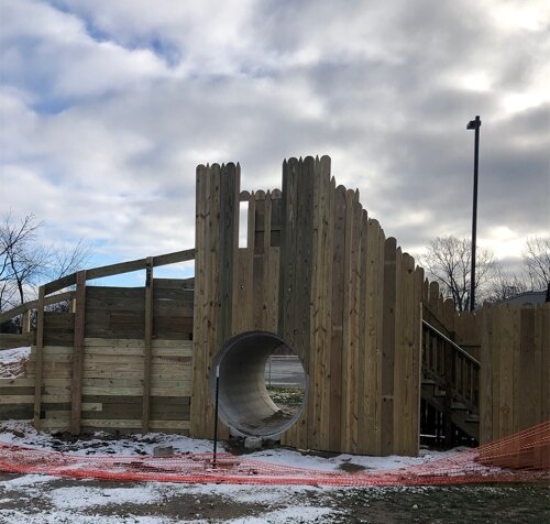 In the winter, the hill over this cement tunnel is used for sledding. This playscape is designed for both children and adults to play.