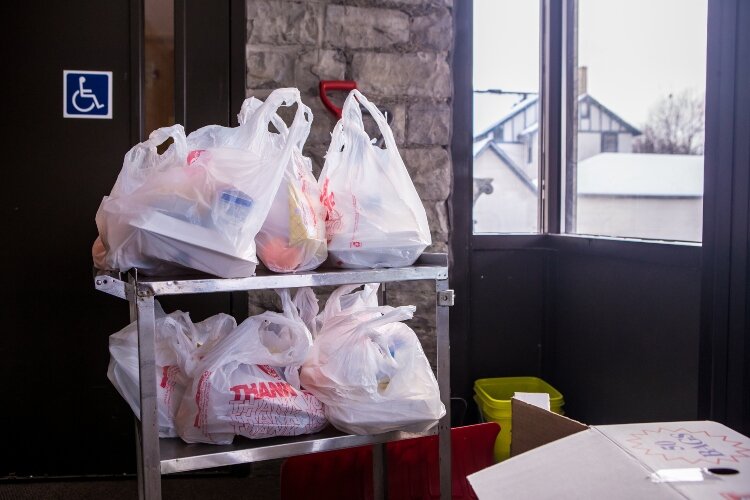Servers hand food out to all who come to the meal, as long as supplies last.