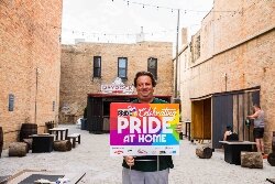 In 2020, the annual Great Lakes Bay Pride Festival turned into an at-home format. Scott Ellis, at right, encouraged people and businesses to display these signs during the festival.