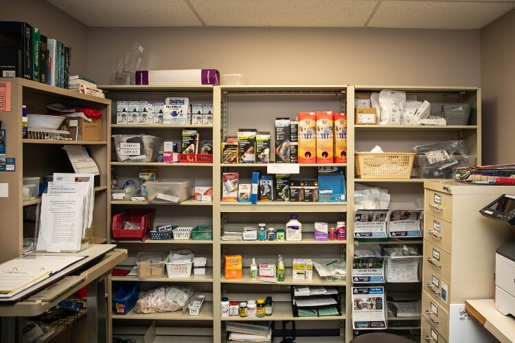 Medical supplies line the shelves of a room behind the reception desk at the Helen M. Nickless Volunteer Clinic.