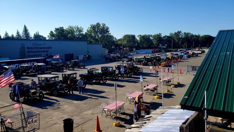 Antique cars fill the parking lot outside Northwoods Wholesale Outlet during a special summer event.