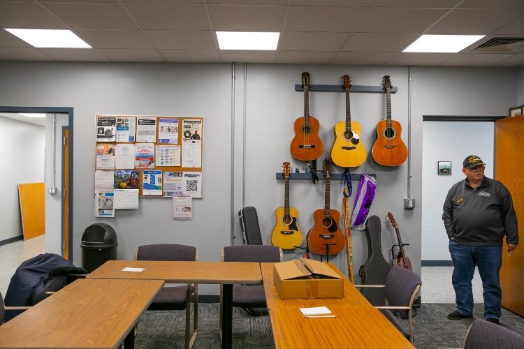 Guitars, which will end up in the hands of area veterans, hang from a classroom wall.