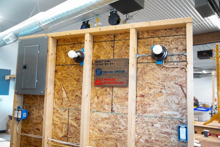 Inside the wood shop, an electric board donated by ESCON Group and Medler Electric is a tool for learning electrical skills.