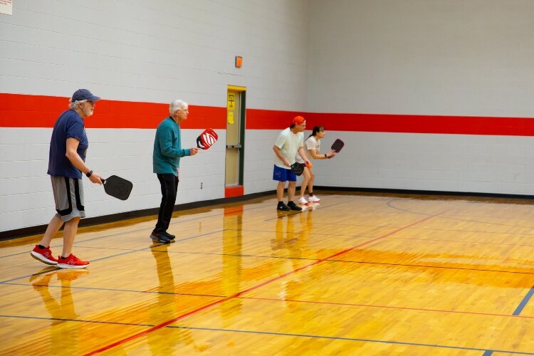 About 100 players a week take advantage of three pickleball courts inside the Bay County Community Center. Here, Ross Jones and Don Walsh play pickleball on one court while Jeff Lynch and Michelle Kulas play on a neighboring court.